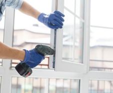 Person adjusting uPVC window with a drill