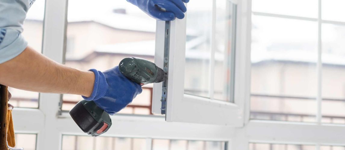 Person adjusting uPVC window with a drill