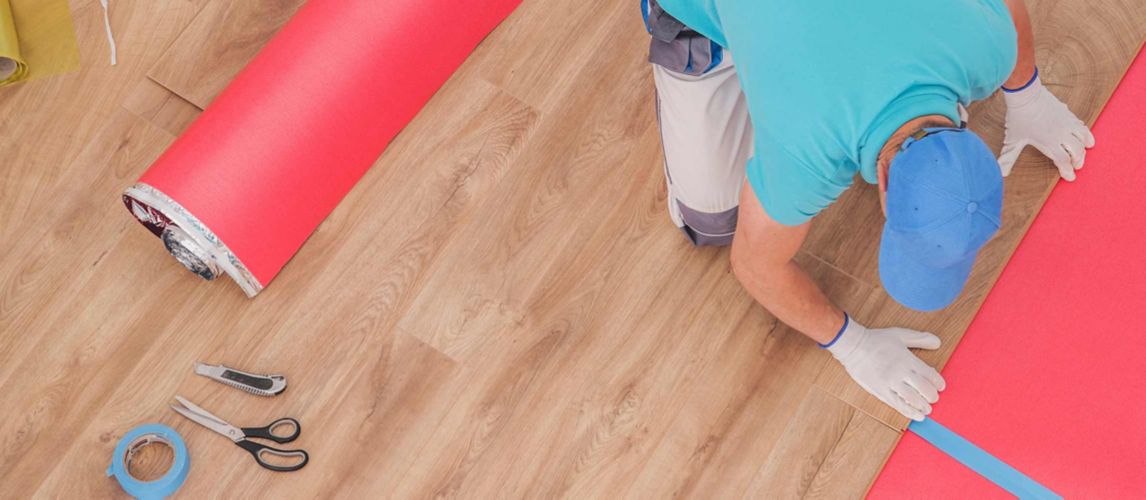 A close-up of worker doing home flooring renovation with vinyl flooring