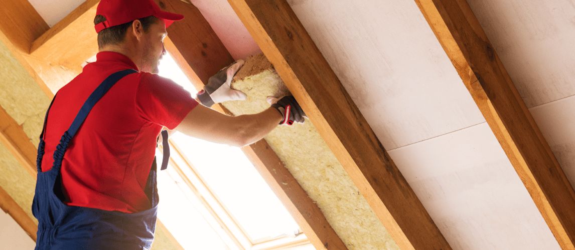 house attic insulation - construction worker installing rock wool in mansard wall