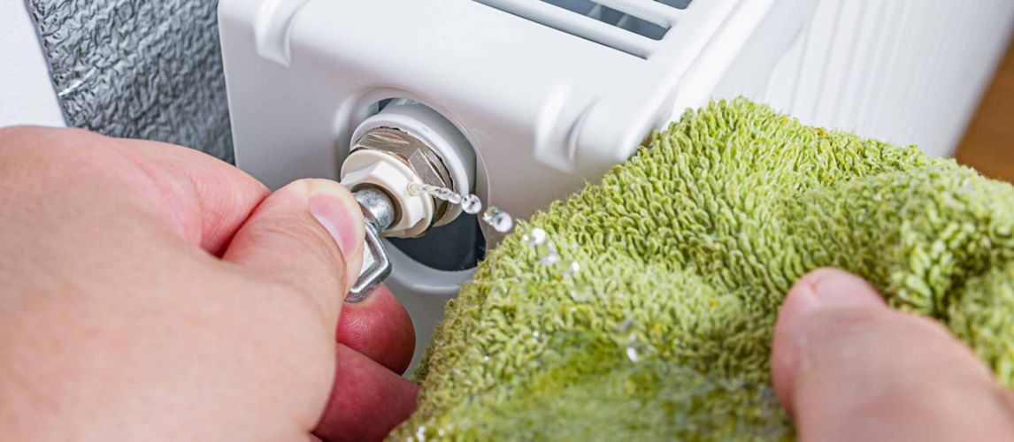 close up view of a person bleeding a radiator