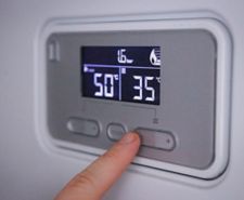 Person adjusting the boiler control panel