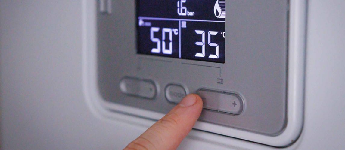 Person adjusting the boiler control panel