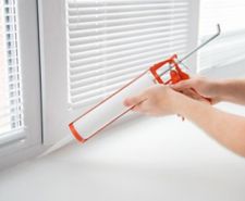 caulking gun being used on window