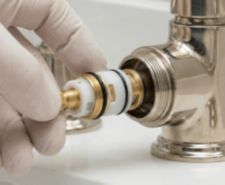 person changing a tap cartridge valve