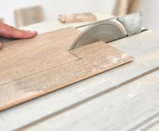 Marked laminate floor being cut by a table saw