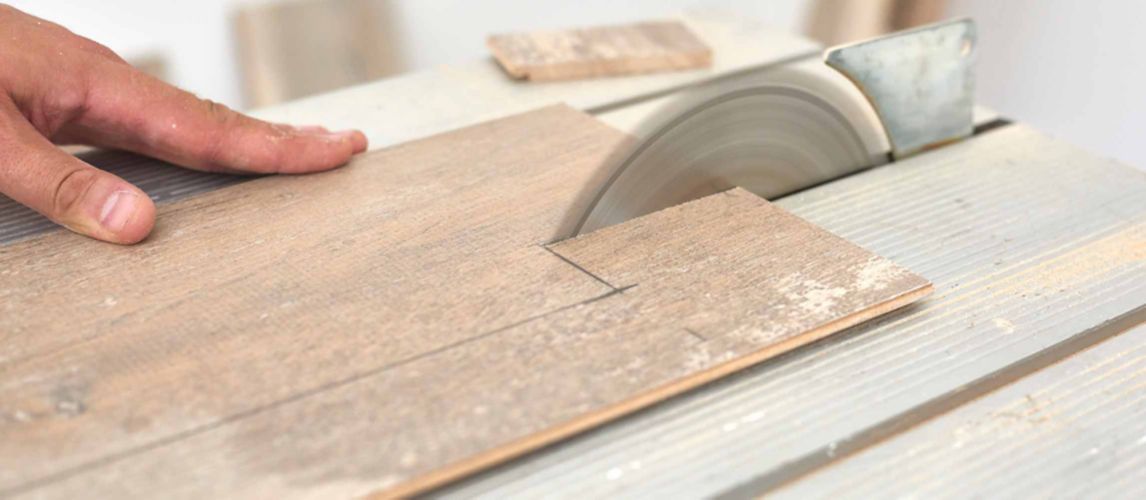 Marked laminate floor being cut by a table saw