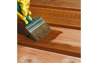 Brush applying treatment to wood decking