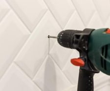 Drill going into white ceramic tile