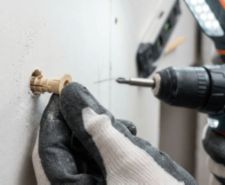 Person placing wall plug in drill hole