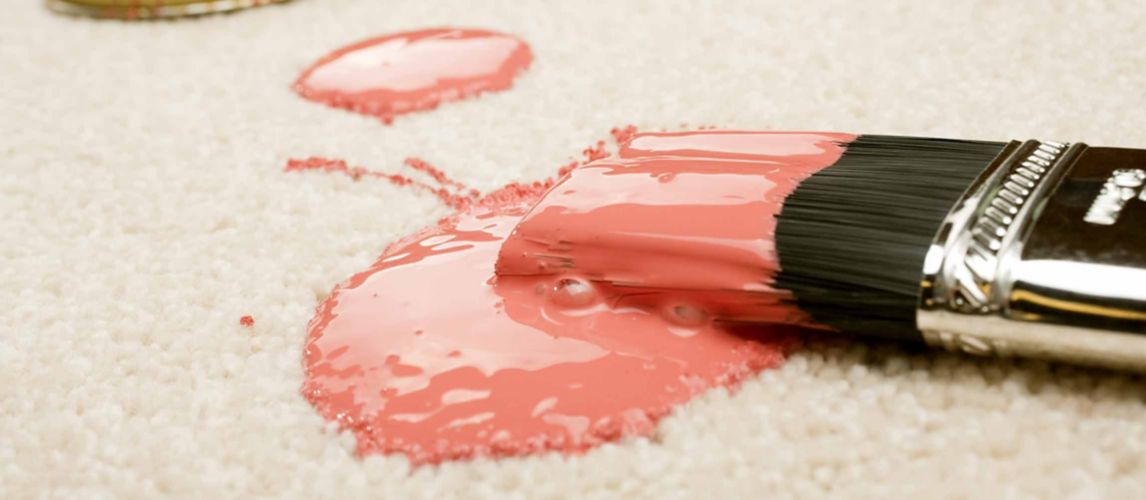Pink paint spilled on cream coloured carpet with brush