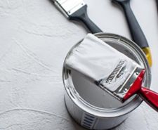 Tin of emulsion paint with a brush on top