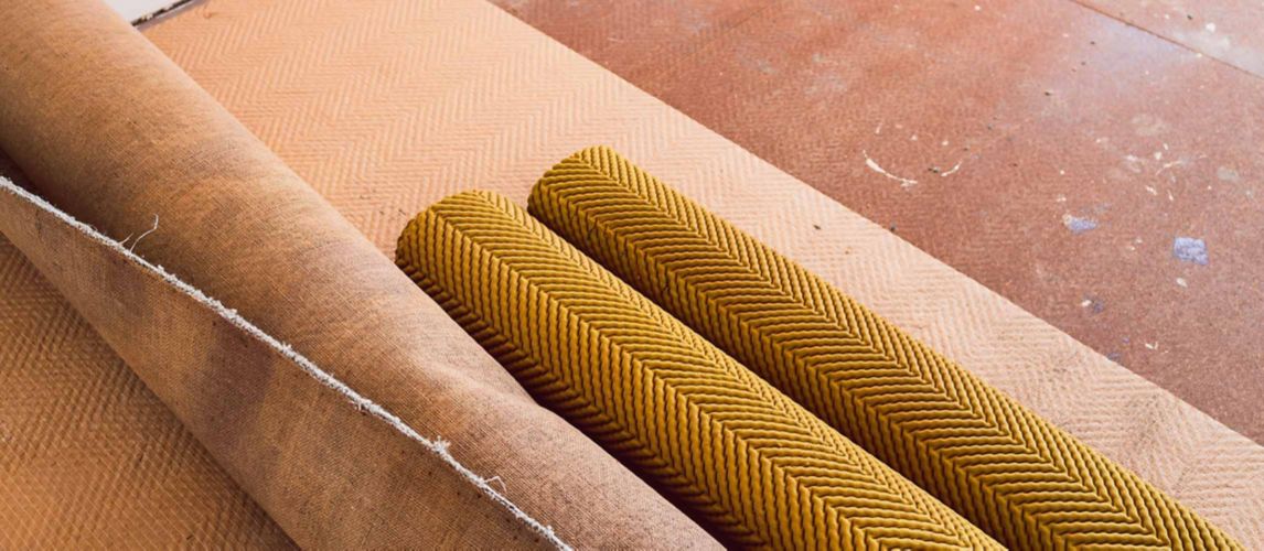 rolled up carpet and floor underlay revealing floorboard in home