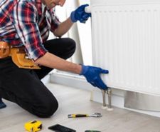 man fitting a radiator in a house