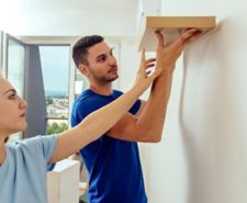 Young couple putting up a floating shelf