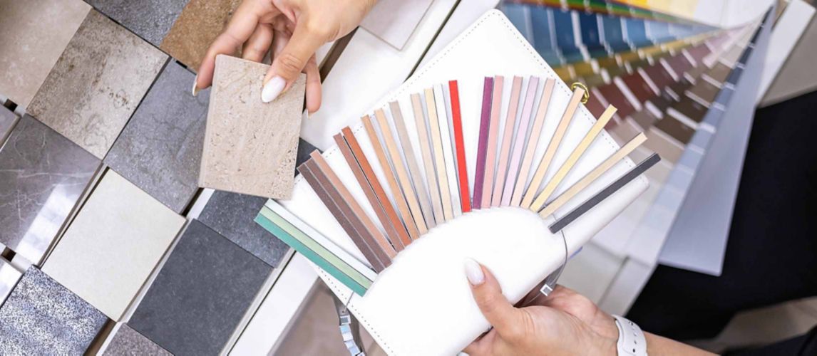 Woman architect designer selects epoxy grout colour for ceramic tiles, comparing colour samples