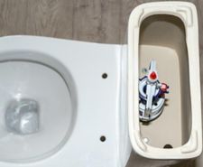 white toilet tank with an open lid and flush system