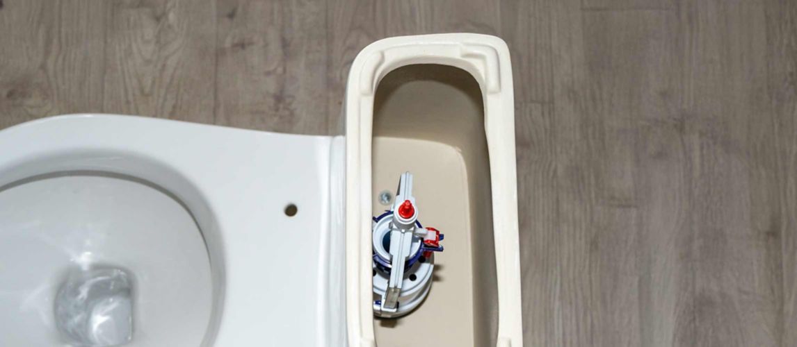 white toilet tank with an open lid and flush system