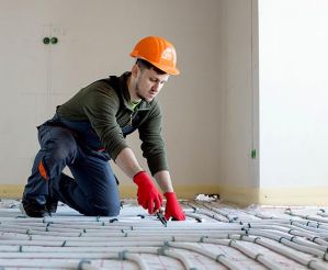 Worker installing underfloor heating.
