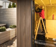 Man Insulating Newly Built Garden Shed with Mineral Wool