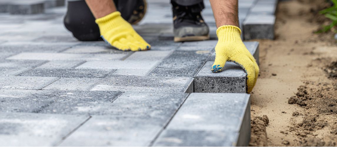 a worker laying bricks for a patio