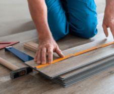 Construction worker laying vinyl flooring