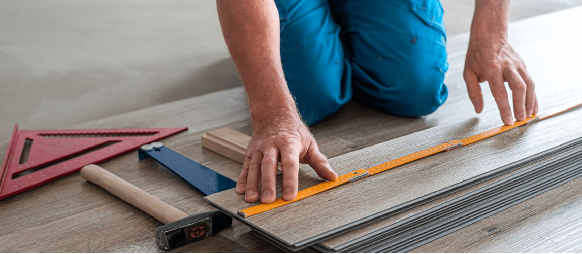 Construction worker laying vinyl flooring