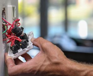 An electrician wiring a light switch