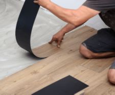 worker installing new vinyl tile floor