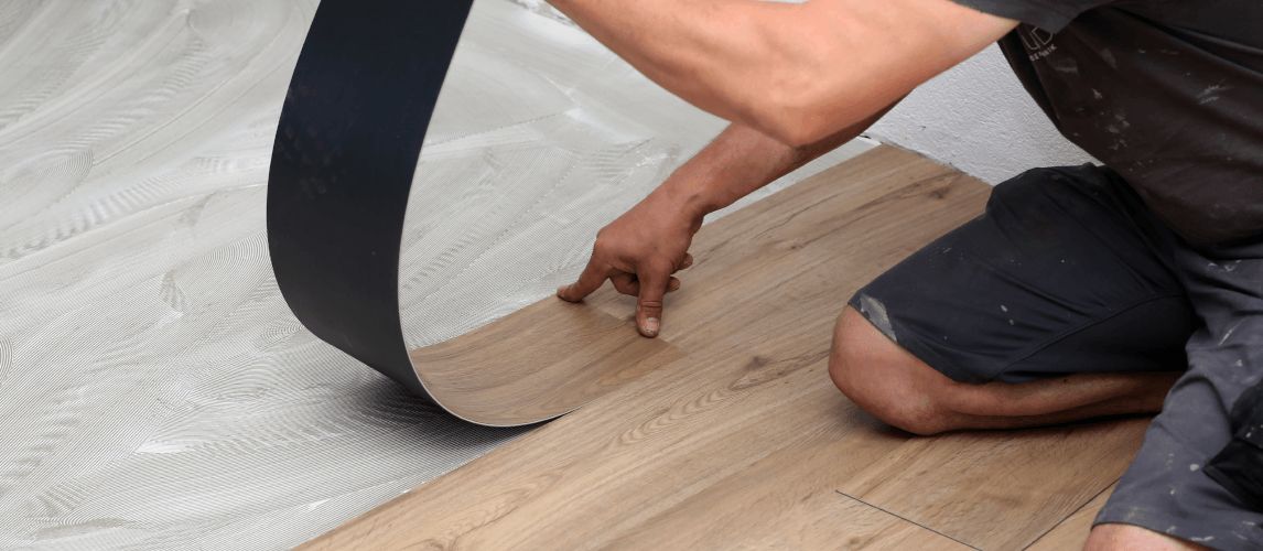 worker installing new vinyl tile floor