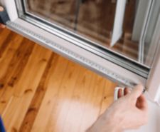 Measuring a window with a measuring tape to fit blinds