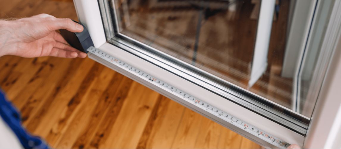 Measuring a window with a measuring tape to fit blinds