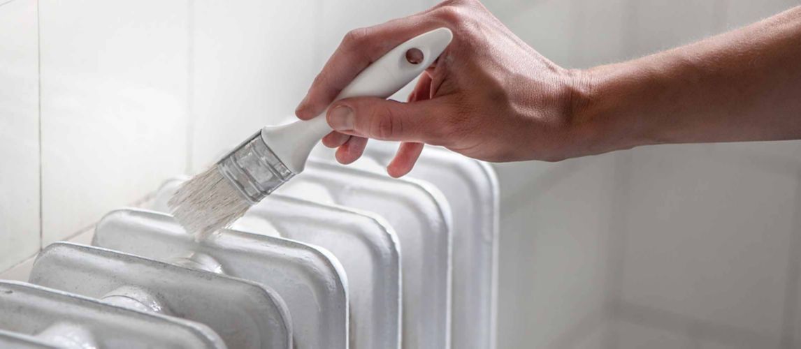 close up of hand painting a radiator