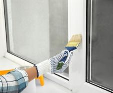 person painting upvc window frame