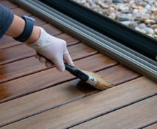 person painting varnished wood
