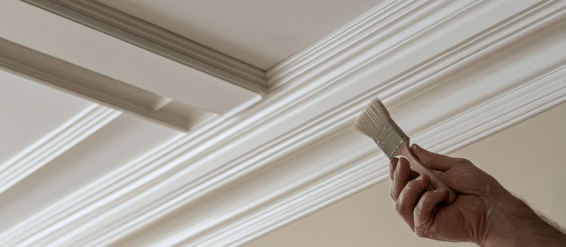 Person touching up paint on trim using a small paint brush with precision.