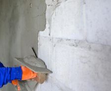 Person plastering a brickwork wall