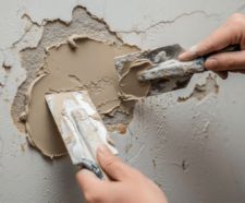 a person applying polyfilla to a hole in a wall