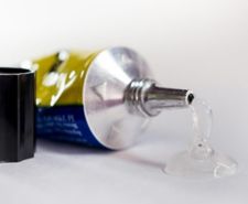 Tube of glue left on its side leaking on a table