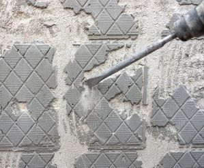 SDS drill being used to remove tile adhesive from a wall