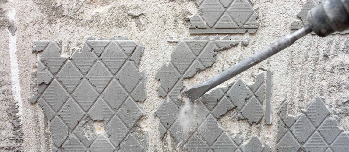 SDS drill being used to remove tile adhesive from a wall