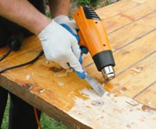 person removing varnish from wood