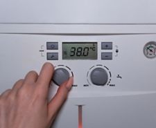 Boiler control panel with someone adjusting the radiator flow temperature knob