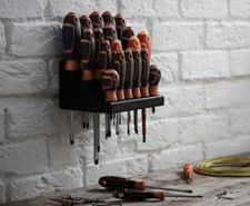 Magnusson 22 piece screwdriver set in a holder fixed to a brick wall above a work surface