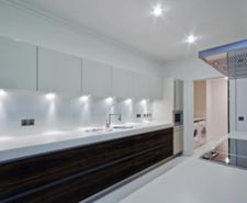 A kitchen with two downlights on the ceiling and six installed under cabinets