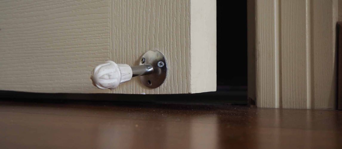 Door spring stopper on a white door.