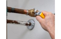 Copper plumbing pipe with brass water supply valve and yellow stopcock handle