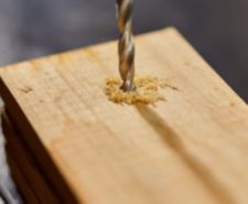 drill bit going into plank of wood