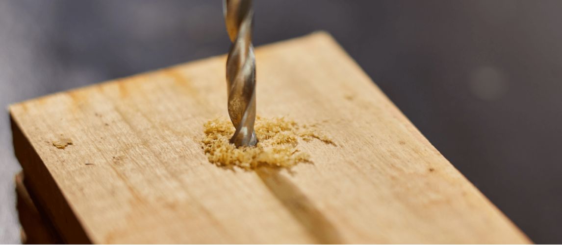 drill bit going into plank of wood