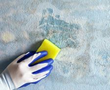 person wearing glove using sugar soap on surface